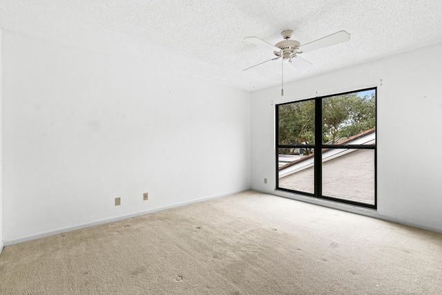 carpeted spare room with ceiling fan and a textured ceiling