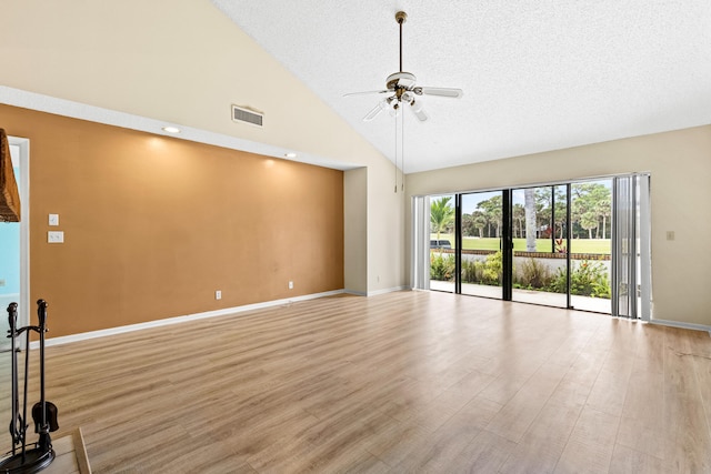 empty room featuring high vaulted ceiling, a textured ceiling, ceiling fan, and light hardwood / wood-style flooring