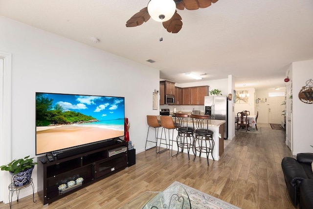 living room featuring light hardwood / wood-style floors and ceiling fan