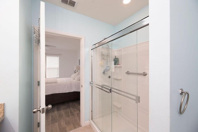 bathroom with wood-type flooring and a shower with door