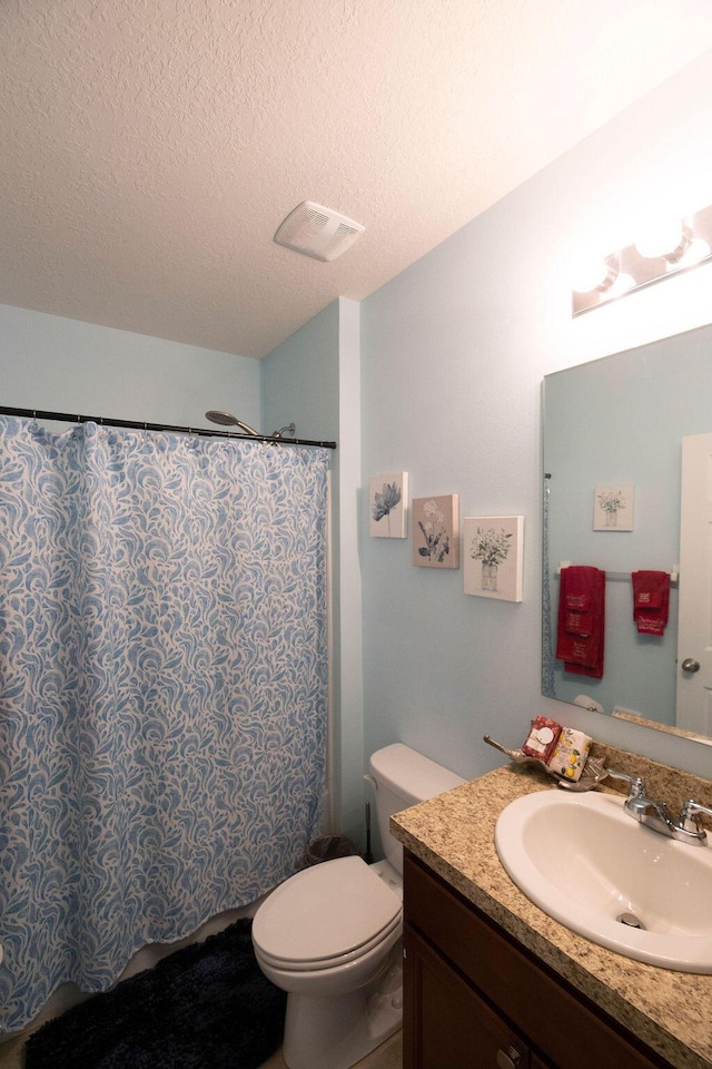 bathroom with toilet, a textured ceiling, and vanity