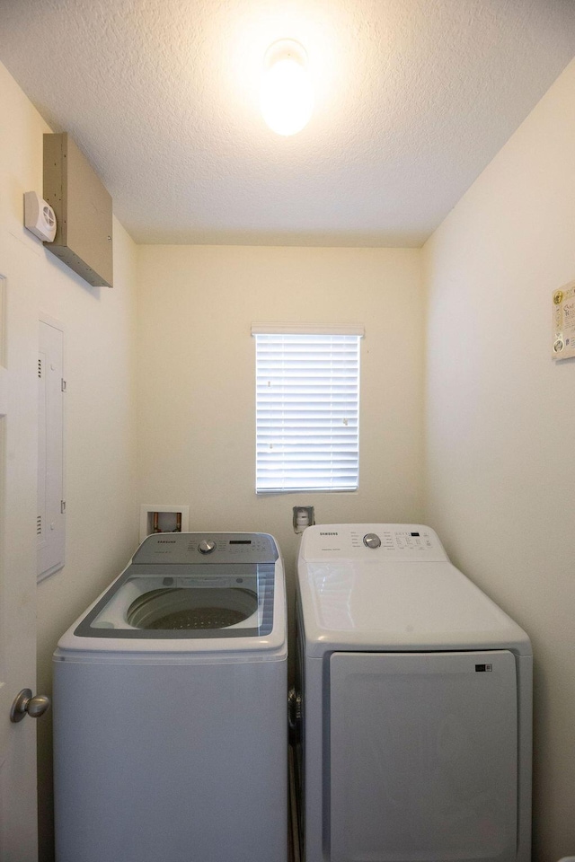 clothes washing area with a textured ceiling and washing machine and dryer