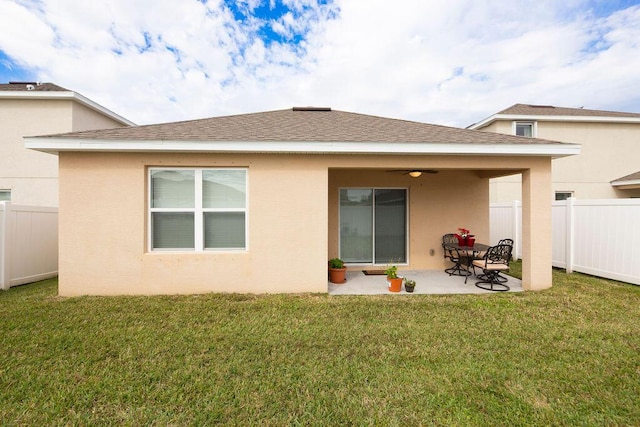 rear view of house featuring ceiling fan, a patio area, and a yard