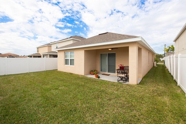 back of property with a patio area and a yard