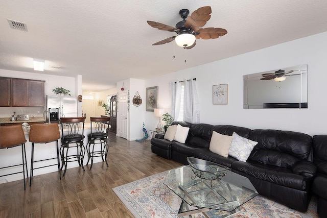 living room with ceiling fan and dark wood-type flooring