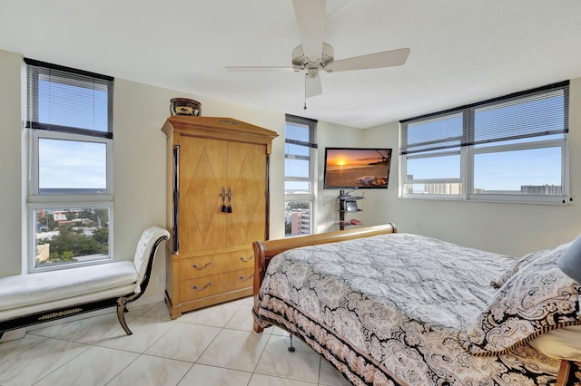 bedroom with ceiling fan, light tile patterned flooring, and multiple windows