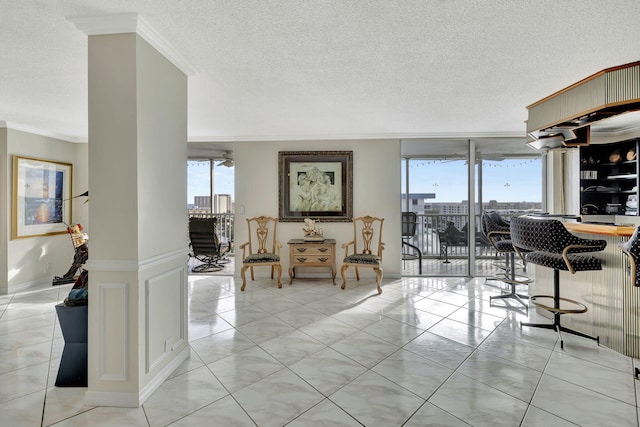 living room featuring a textured ceiling, light tile patterned floors, ornamental molding, and expansive windows