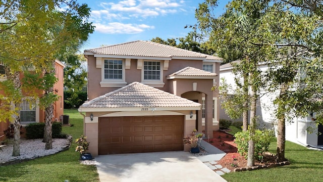 mediterranean / spanish home with a garage, central AC unit, and a front lawn