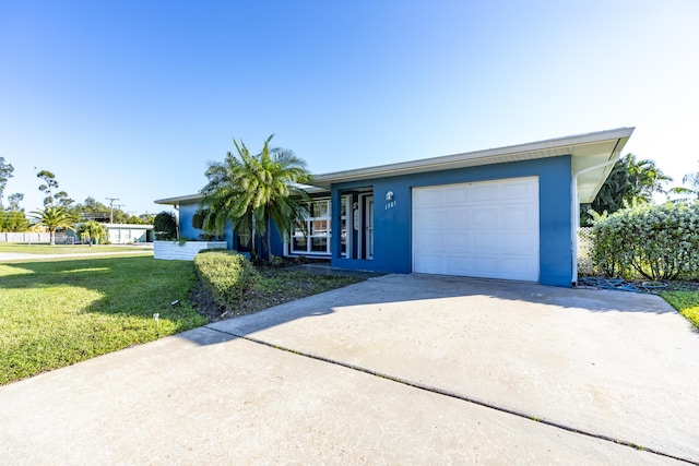 single story home featuring a garage and a front yard