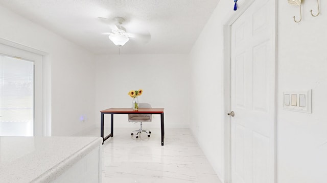 office space with a textured ceiling and ceiling fan