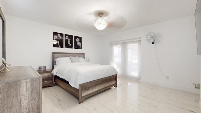 bedroom featuring ceiling fan and a textured ceiling