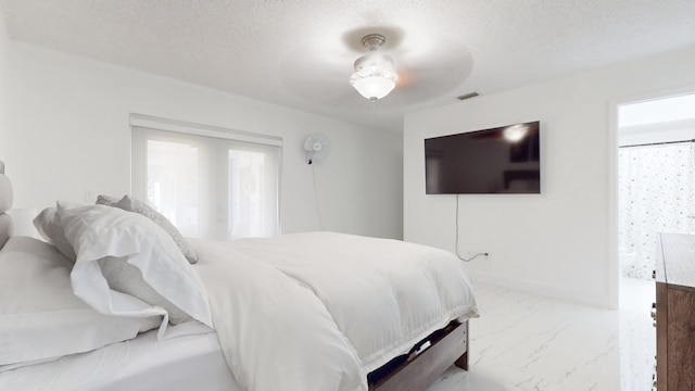 bedroom with a textured ceiling and ceiling fan