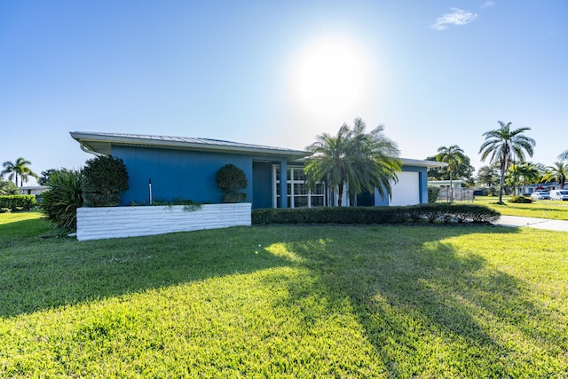 single story home with a front yard and a garage