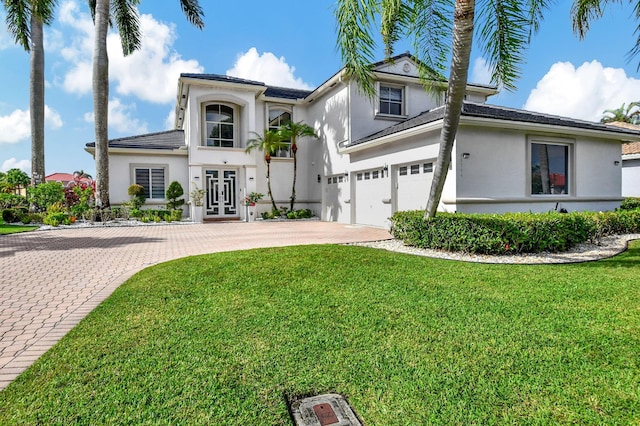 view of front of home with a front yard and a garage