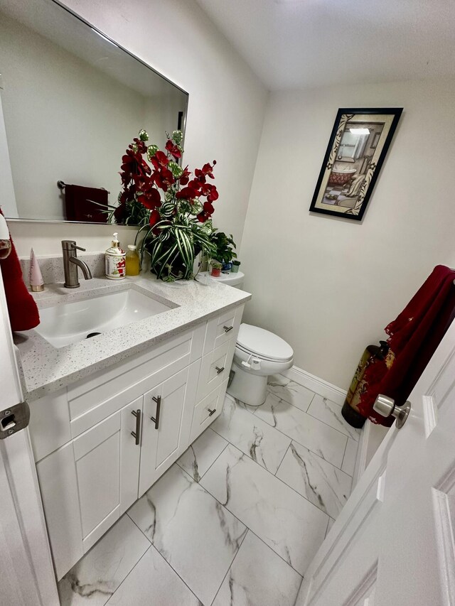 bathroom with a shower with shower door, vanity, and toilet