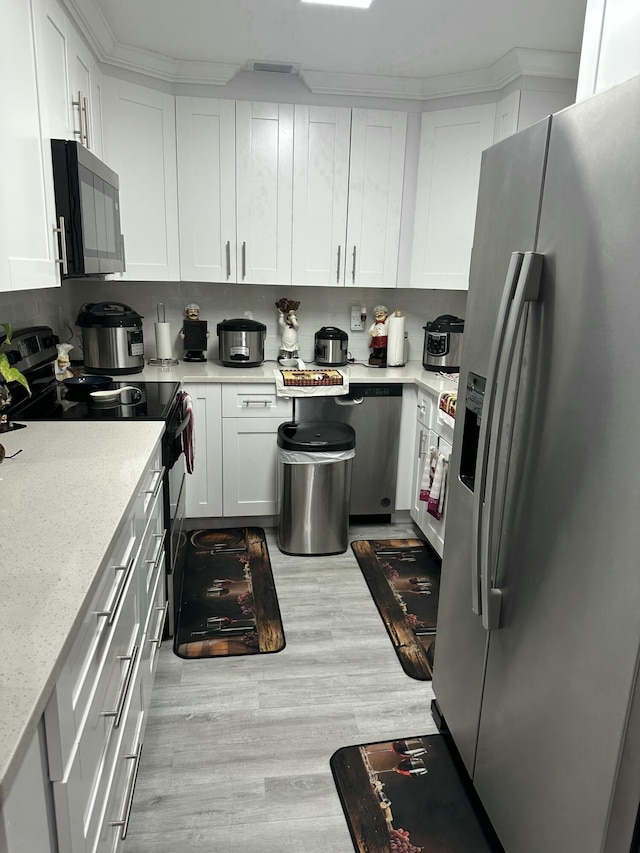 kitchen featuring stainless steel fridge with ice dispenser, white cabinetry, electric range, and light stone countertops