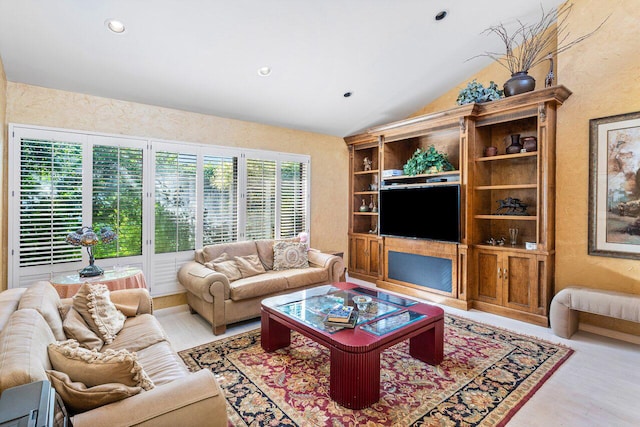 living room with light wood-type flooring, vaulted ceiling, and a wealth of natural light