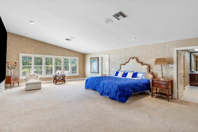 carpeted bedroom with lofted ceiling and ensuite bath