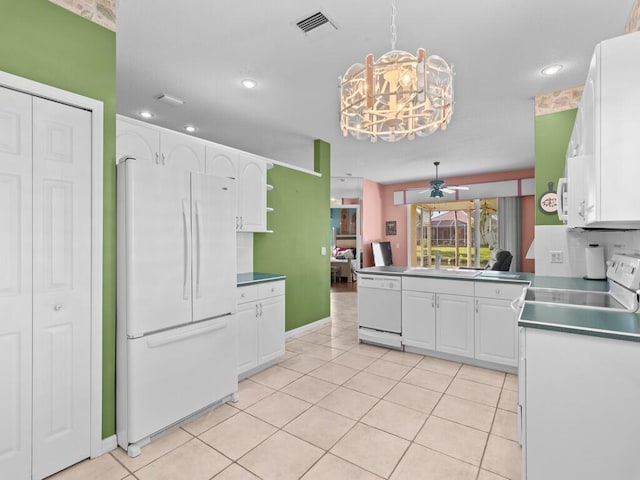 kitchen with kitchen peninsula, decorative backsplash, white appliances, hanging light fixtures, and white cabinets