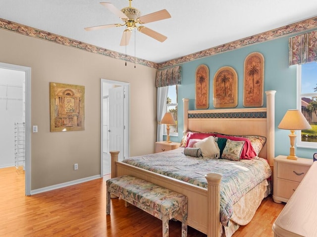 bedroom featuring light wood-type flooring, ceiling fan, and multiple windows