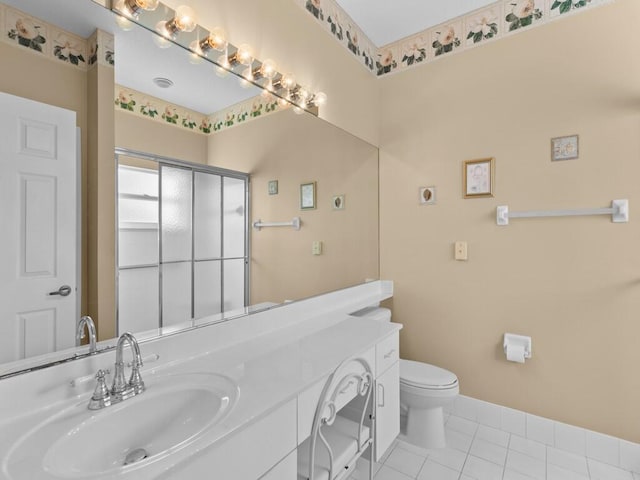 bathroom with toilet, a shower with door, vanity, and tile patterned flooring