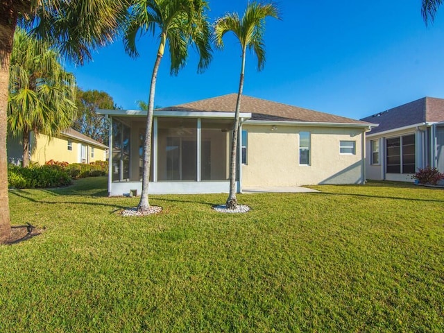 rear view of property with a sunroom and a lawn