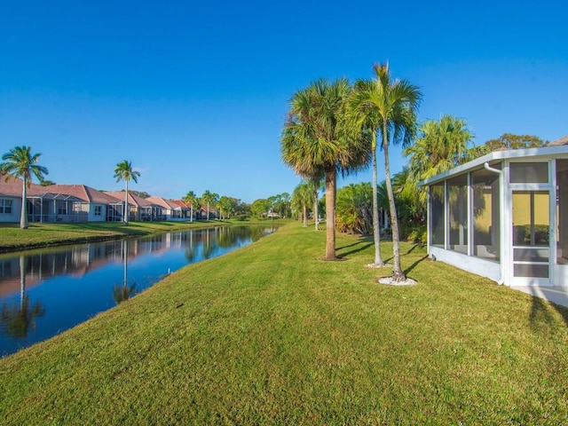 view of yard featuring a water view and a sunroom