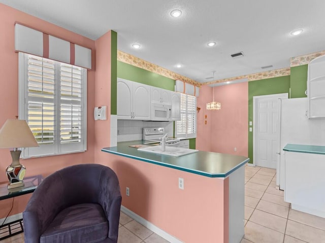 kitchen featuring decorative light fixtures, kitchen peninsula, decorative backsplash, white appliances, and white cabinetry