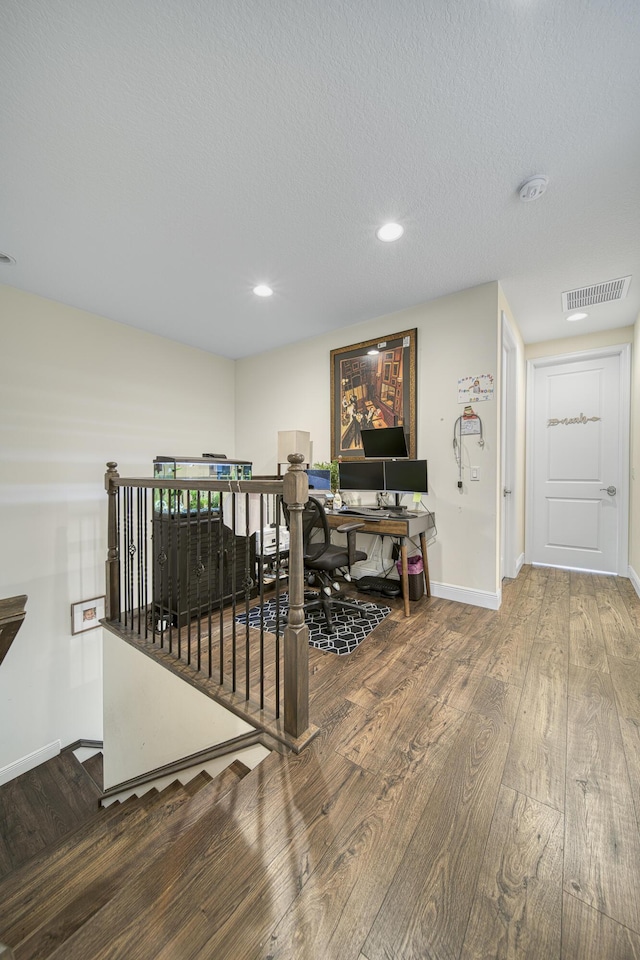 office area with wood-type flooring and a textured ceiling