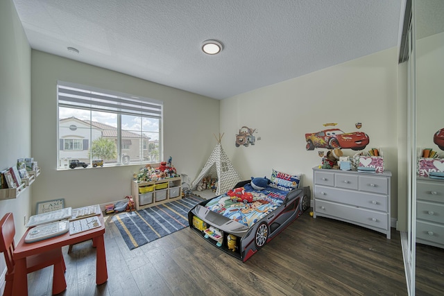 bedroom with a textured ceiling and dark hardwood / wood-style floors