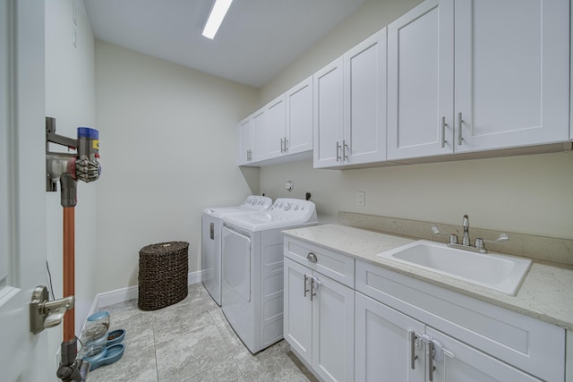 washroom featuring cabinets, sink, and washing machine and clothes dryer