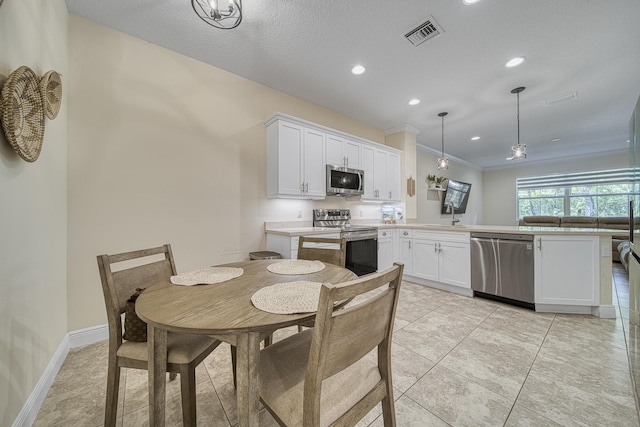 kitchen featuring white cabinetry, stainless steel appliances, hanging light fixtures, kitchen peninsula, and light tile patterned floors