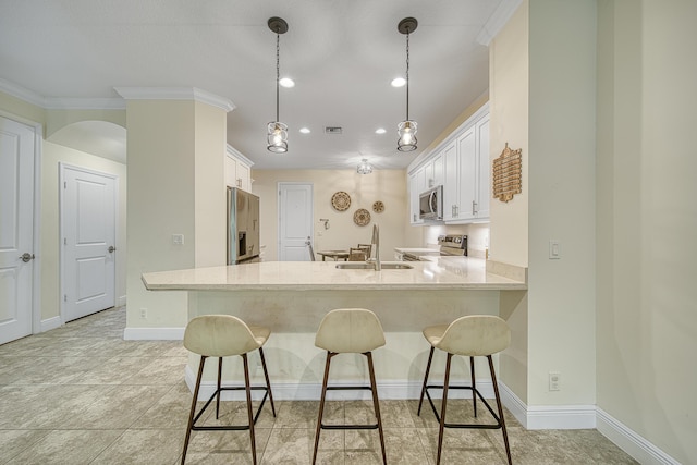 kitchen featuring kitchen peninsula, stainless steel appliances, crown molding, white cabinets, and sink