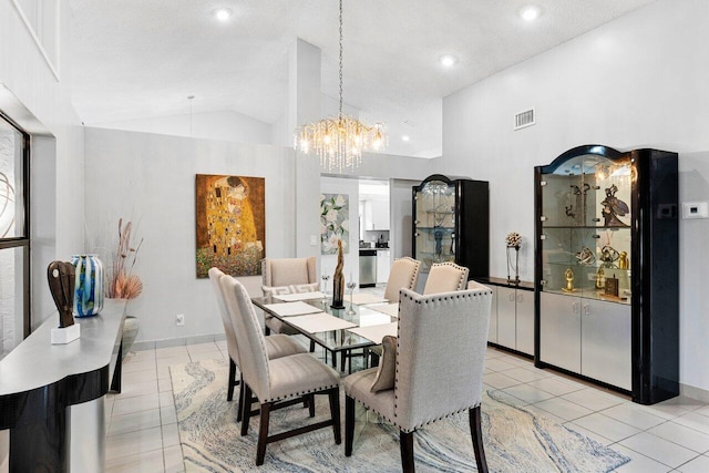 dining space with light tile patterned flooring, high vaulted ceiling, and an inviting chandelier