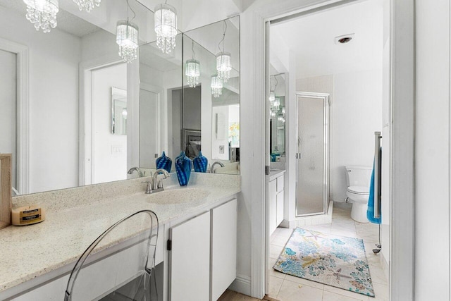 bathroom featuring tile patterned flooring, toilet, vanity, and walk in shower