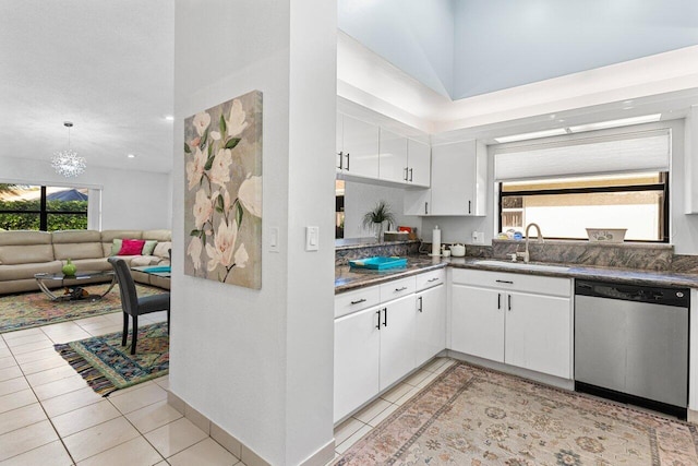 kitchen with a wealth of natural light, dishwasher, sink, white cabinets, and light tile patterned floors