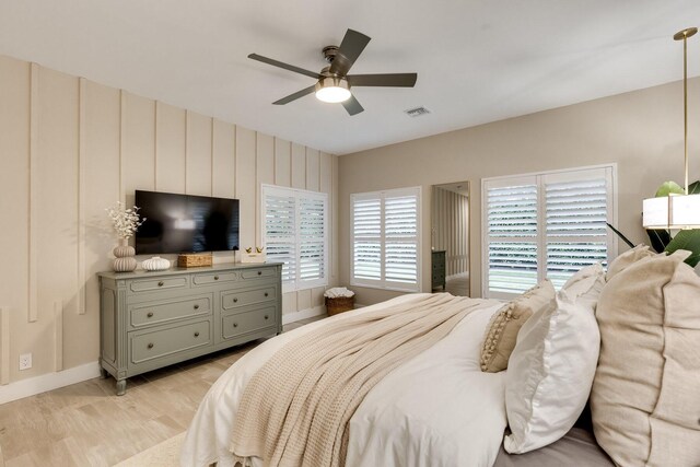 bedroom featuring ceiling fan, hardwood / wood-style floors, and multiple windows