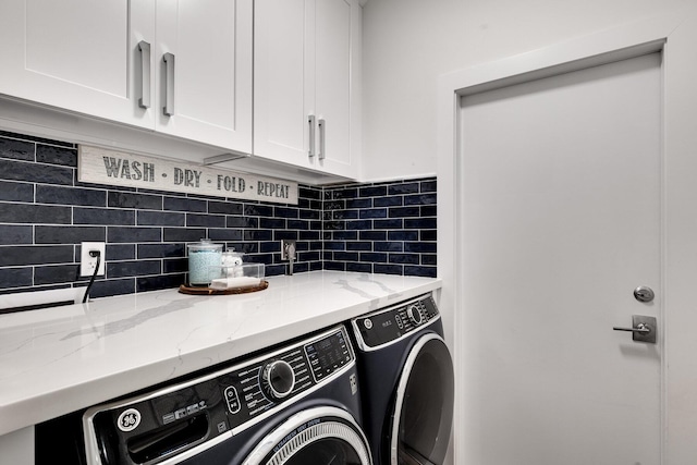 washroom featuring cabinets and washer and dryer