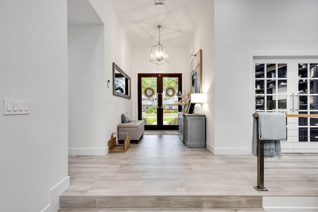 entrance foyer with a chandelier and french doors