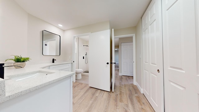 bathroom with toilet, vanity, walk in shower, and hardwood / wood-style floors