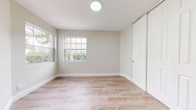 unfurnished bedroom featuring a closet and light hardwood / wood-style floors