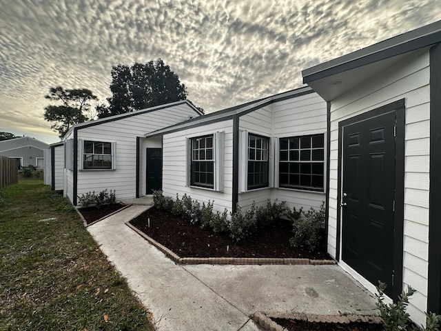 exterior entry at dusk with a lawn