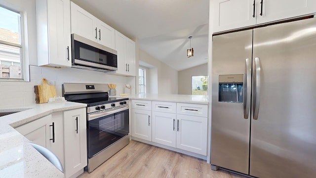 kitchen featuring light stone counters, white cabinets, decorative backsplash, and appliances with stainless steel finishes