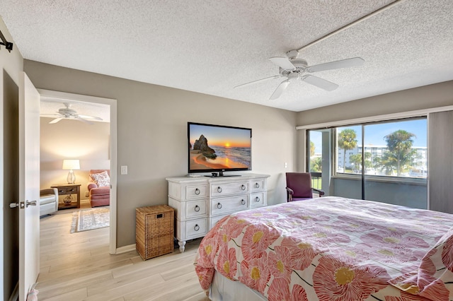 bedroom with ceiling fan, light hardwood / wood-style floors, and a textured ceiling