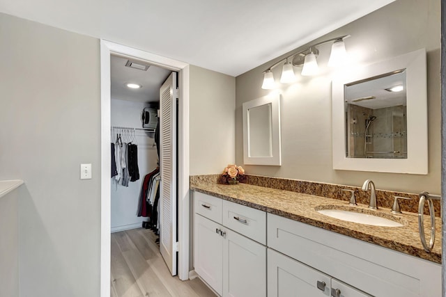 bathroom featuring vanity, hardwood / wood-style floors, and walk in shower