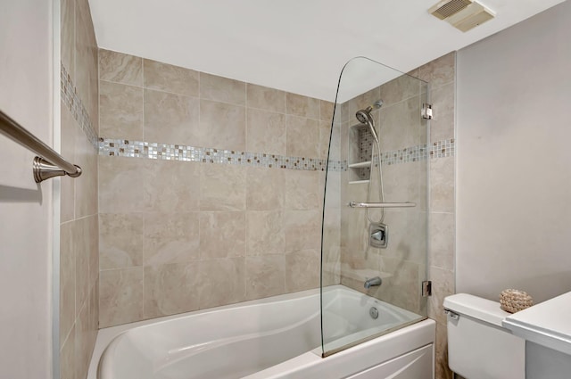 bathroom with toilet and tiled shower / bath combo