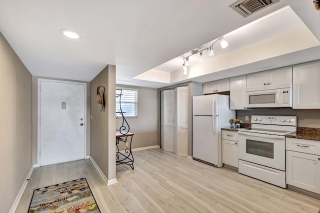 kitchen with white cabinetry, rail lighting, white appliances, and light hardwood / wood-style floors