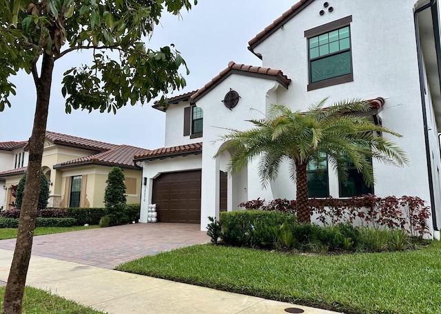 mediterranean / spanish house with a front yard and a garage