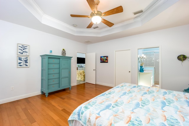 bedroom featuring ceiling fan, light hardwood / wood-style floors, ornamental molding, and a raised ceiling