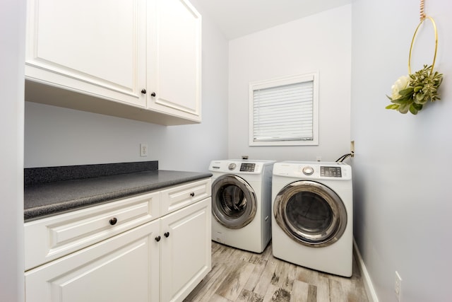 clothes washing area featuring light wood-type flooring, cabinets, and washing machine and clothes dryer